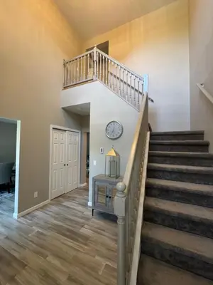 a staircase in a home with a clock on the wall at Escape to Luxury in the Poconos Your Year-Round Family Retreat in Daleville