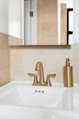 a bathroom with a sink and a gold faucet at Studio Nolita in New York