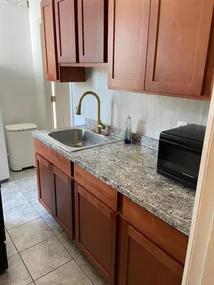 a kitchen counter with a sink and a microwave at Cjay home 3 in Jersey City