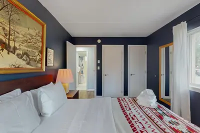 a bedroom with a white bed with blue walls at 5A Mountain Village - Unit A in Dover