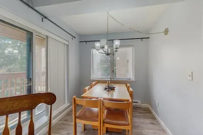 a dining room with a table and chairs and a chandelier at 5A Mountain Village - Unit A in Dover