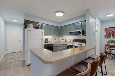 a kitchen with green cabinets and a white refrigerator at 5A Mountain Village - Unit A in Dover