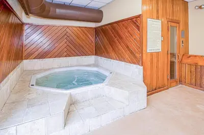 a jacuzzi tub in a room with wooden walls at 5A Mountain Village - Unit A in Dover