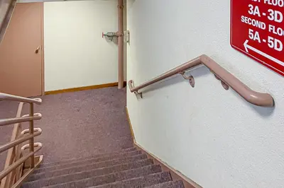 a hallway with stairs and a sign on the wall at 5B Mountain Village- Unit B in Dover