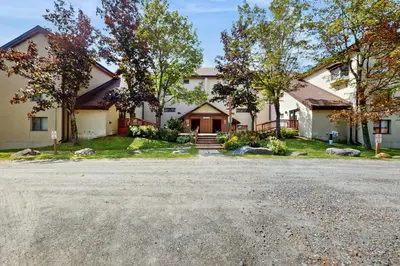 a large white house with a driveway at 5B Mountain Village- Unit B in Dover