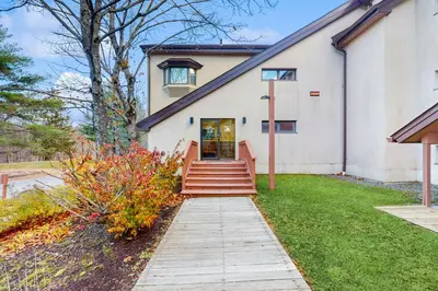 a house with a staircase leading to the front door at 5B Mountain Village- Unit B in Dover
