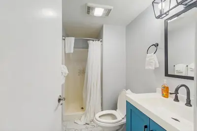 a white bathroom with a toilet and a sink at 5B Mountain Village- Unit B in Dover