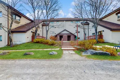 a large white building with a driveway in front of it at 5B Mountain Village- Unit B in Dover