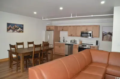 a living room with a couch and a table and a kitchen at Luxury 2 Bedroom Townhome 102 in Wilmington