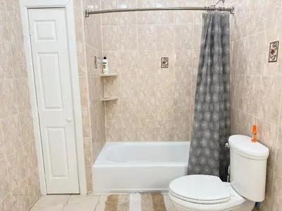 a bathroom with a tub and a toilet and a shower at Huge apartment near NYC, Parking in North Bergen