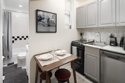 a small kitchen with a table and a sink at Serene 1B Upper East Side Retreat in New York