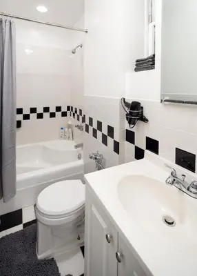 a white bathroom with a toilet and a sink at Serene 1B Upper East Side Retreat in New York
