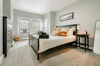 a bedroom with a bed and a desk in it at A brick's throw away to Sally's! in New Haven