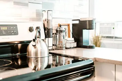 a tea kettle sitting on top of a stove in a kitchen at A brick's throw away to Sally's! in New Haven