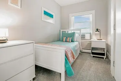 a small bedroom with a bed and a window at A brick's throw away to Sally's! in New Haven