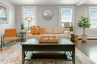 a living room with a couch and a table at A brick's throw away to Sally's! in New Haven