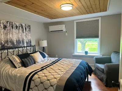 a bedroom with a bed and a couch and a window at Woodford Rest in Woodford