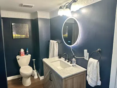 a bathroom with a toilet and a sink and a mirror at Woodford Rest in Woodford