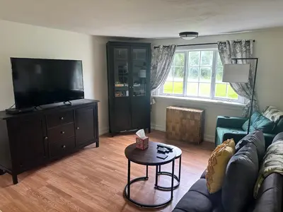 a living room with a couch and a flat screen tv at Woodford Rest in Woodford