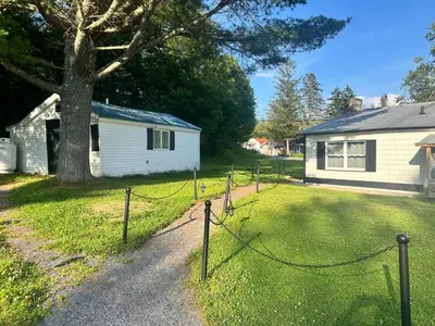 a yard with a fence in front of a house at Woodford Rest in Woodford