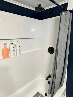 a bathroom with a bath tub with two bottles of soap at Woodford Rest in Woodford