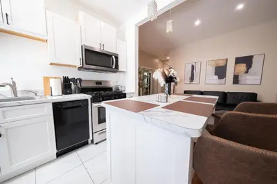 a kitchen with white cabinets and a counter top at Sunlit 2BR Central Park North elevator & laundry in New York