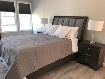 a bedroom with a large bed and two windows at End of the Rainbow in Ballston Lake