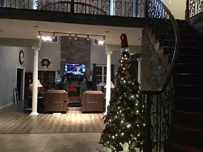 a christmas tree in a living room with a staircase at End of the Rainbow in Ballston Lake