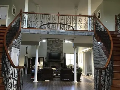 a spiral staircase in a house with a living room at End of the Rainbow in Ballston Lake