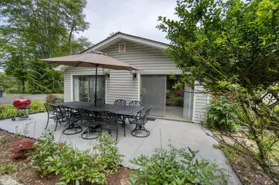 a patio with a table and chairs and an umbrella at Catskills Getaway 3BR Retreat with Media Room, Near Casino, Bethel Woods and More in Glen Wild