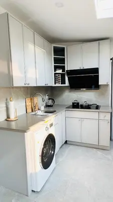a white kitchen with a washing machine in it at Line&Light