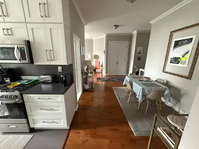 a kitchen with white cabinets and a table with chairs at Central Park north spacious residence in New York