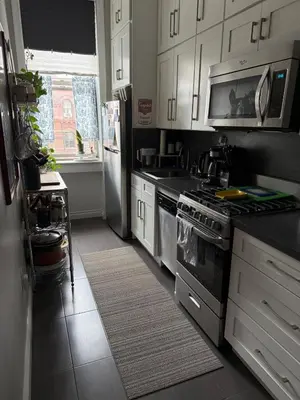 a kitchen with white cabinets and a stove top oven at Central Park north spacious residence in New York