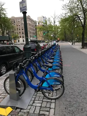 a row of blue bikes parked next to a street at Central Park north spacious residence in New York