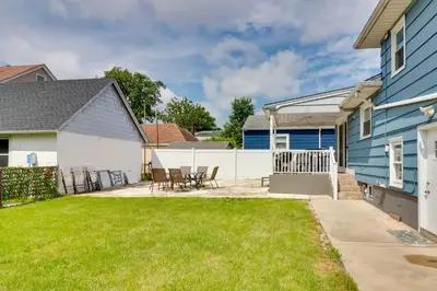 a backyard with chairs and a blue house at 5 Mi to Dtwn Newark Hillside Vacation Rental in Hillside