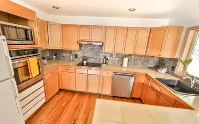 a kitchen with wooden cabinets and stainless steel appliances at Secluded Retreat w Hot Tub in Windham in Windham