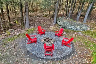 a group of red chairs and a fire pit at Secluded Retreat w Hot Tub in Windham in Windham