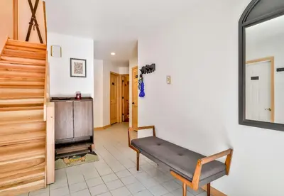 a living room with a bench and a staircase at Secluded Retreat w Hot Tub in Windham in Windham