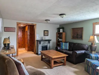 a living room with a couch and a fireplace at Logged Inn in Caroga Lake