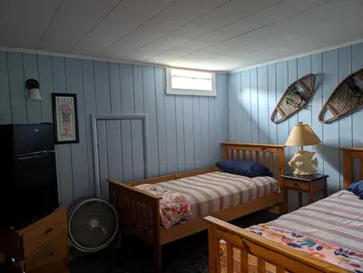 a bedroom with two beds and a tv in it at Logged Inn in Caroga Lake