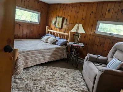 a bedroom with a bed and a couch at Logged Inn in Caroga Lake