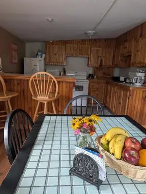 a kitchen with a table with a basket of fruit at Logged Inn in Caroga Lake