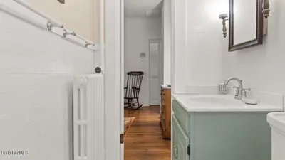 a white bathroom with a sink and a mirror at Berkshire Vacation Rentals 1900s Factory Turned Modern Berkshires Retreat in Great Barrington