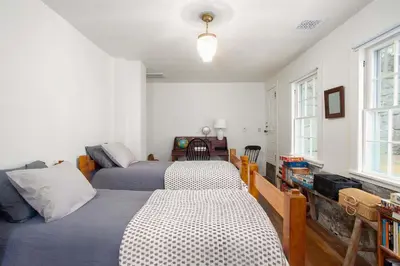a bedroom with two beds and a window at Berkshire Vacation Rentals 1900s Factory Turned Modern Berkshires Retreat in Great Barrington