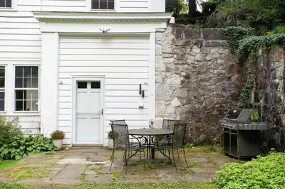 a table and chairs in front of a white house at Berkshire Vacation Rentals 1900s Factory Turned Modern Berkshires Retreat in Great Barrington