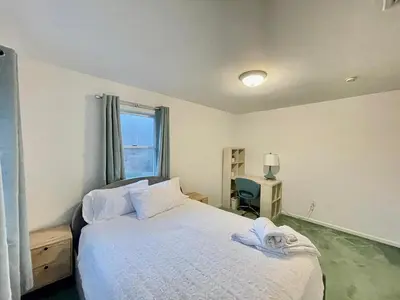 a bedroom with a bed and a desk and a window at Charming Country Home with Hot Tub, Pond & Creek in New Paltz