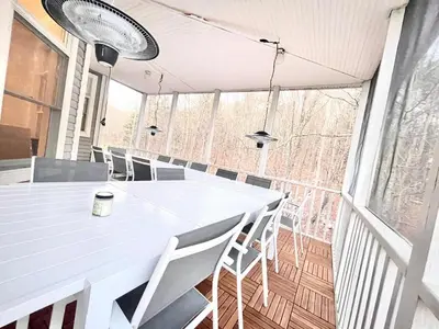 a white table and chairs in a room with windows at Charming Country Home with Hot Tub, Pond & Creek in New Paltz