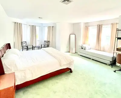 a bedroom with a bed and a couch and windows at Dome 2Home Villa - Hot Tubs, Sauna & Piano in New Paltz