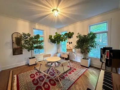 a living room with a table and chairs and windows at Dome 2Home Villa - Hot Tubs, Sauna & Piano in New Paltz