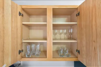 a cabinet filled with glasses sitting on shelves at Near YALE - Beautiful Waterfront Townhouse in New Haven in New Haven